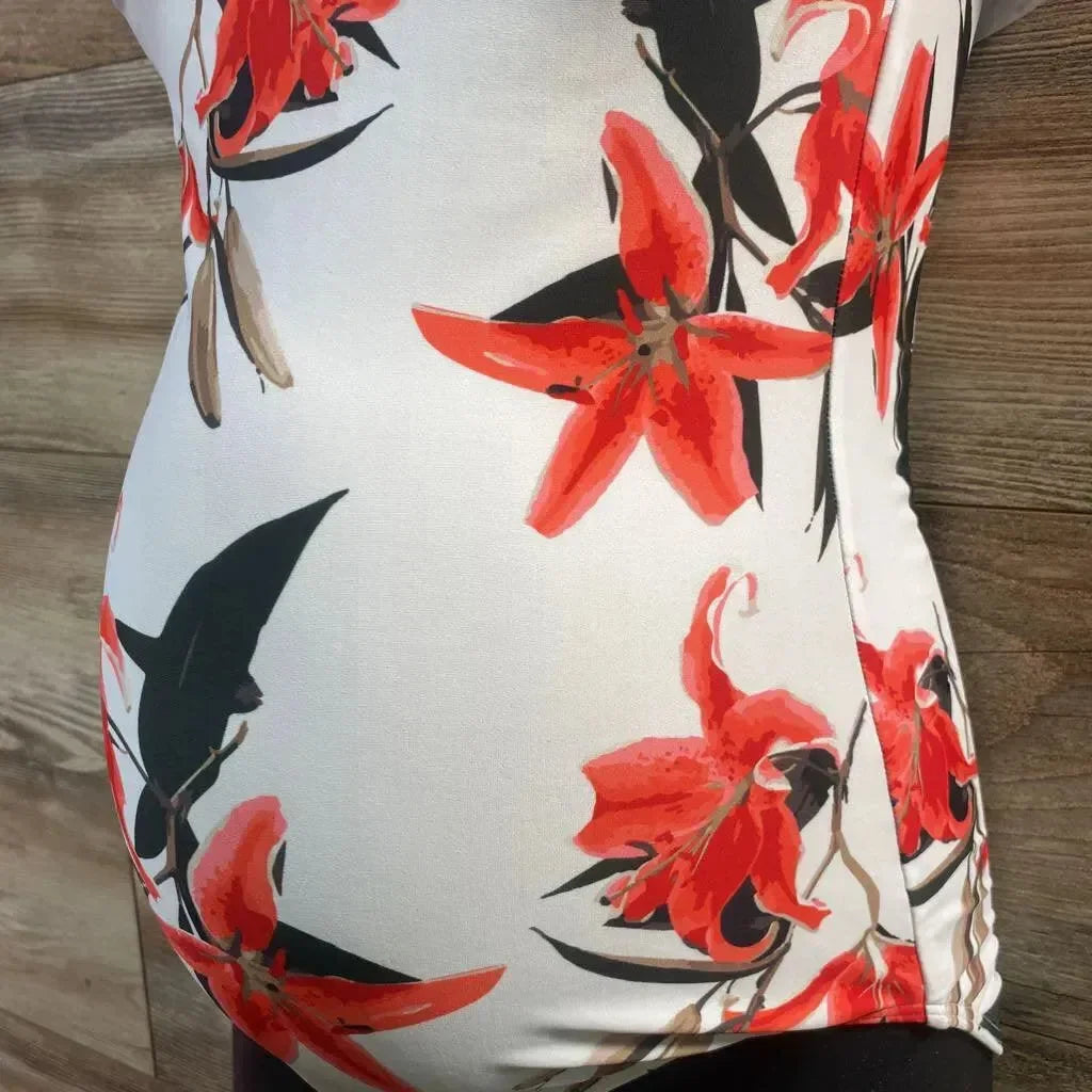 Side view of white one-piece floral maternity swimsuit with orange flowers, ruched side and tummy coverage on wood background