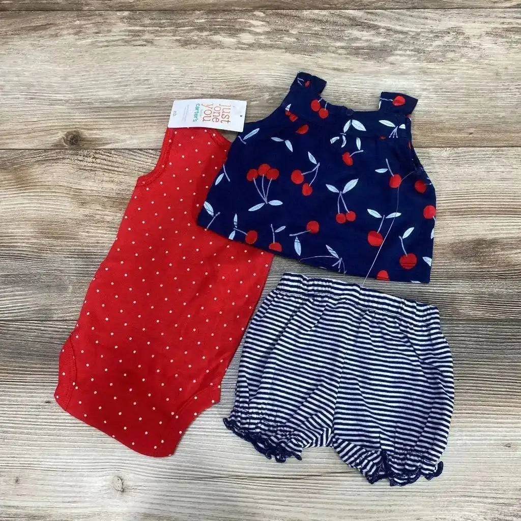 Flat lay of 3-piece baby set: red polka-dot bodysuit, navy cherry-print top, and navy-and-white striped bloomers on wood