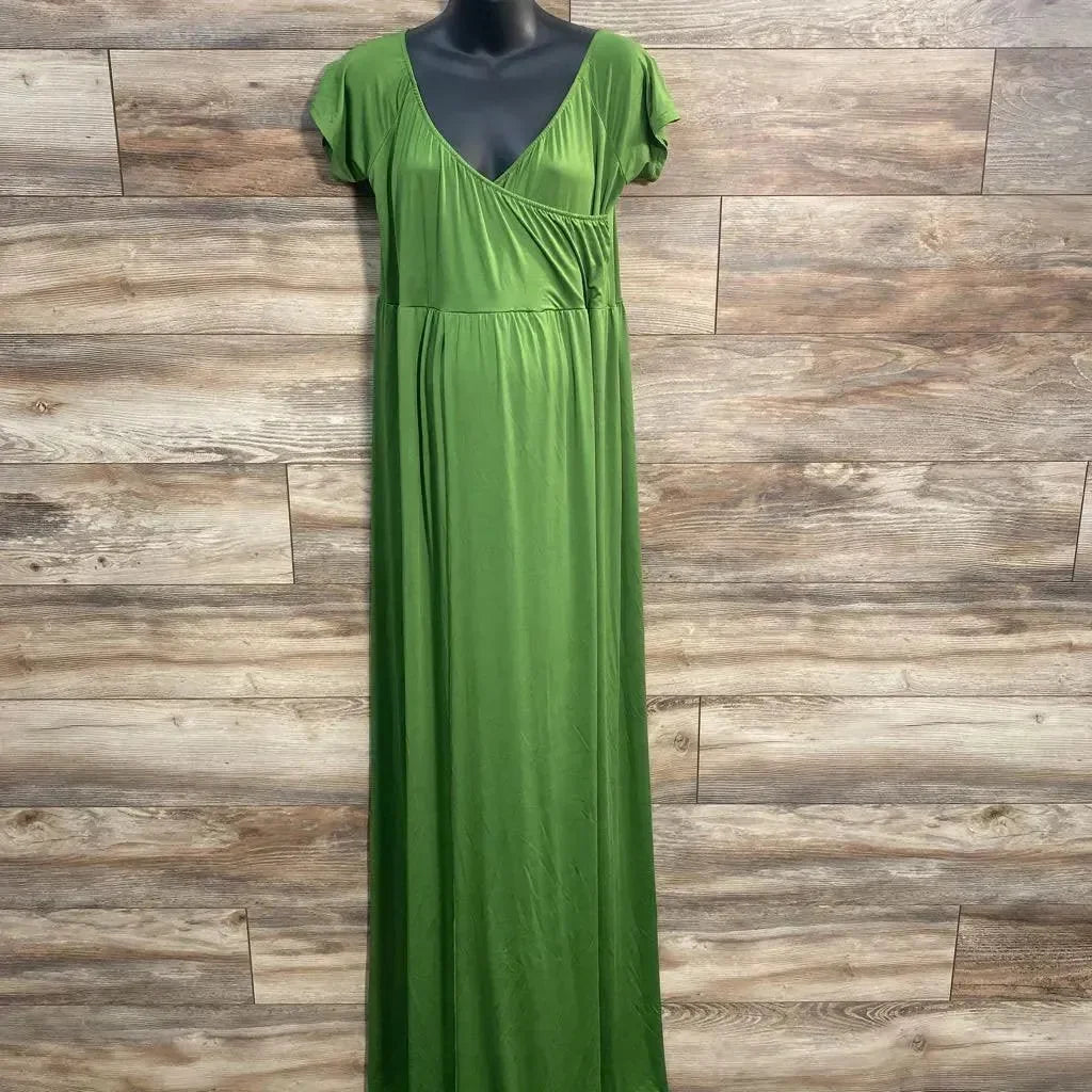 Front of green maxi dress with surplice V-neck, empire waist and cap sleeves on mannequin against wood plank backdrop