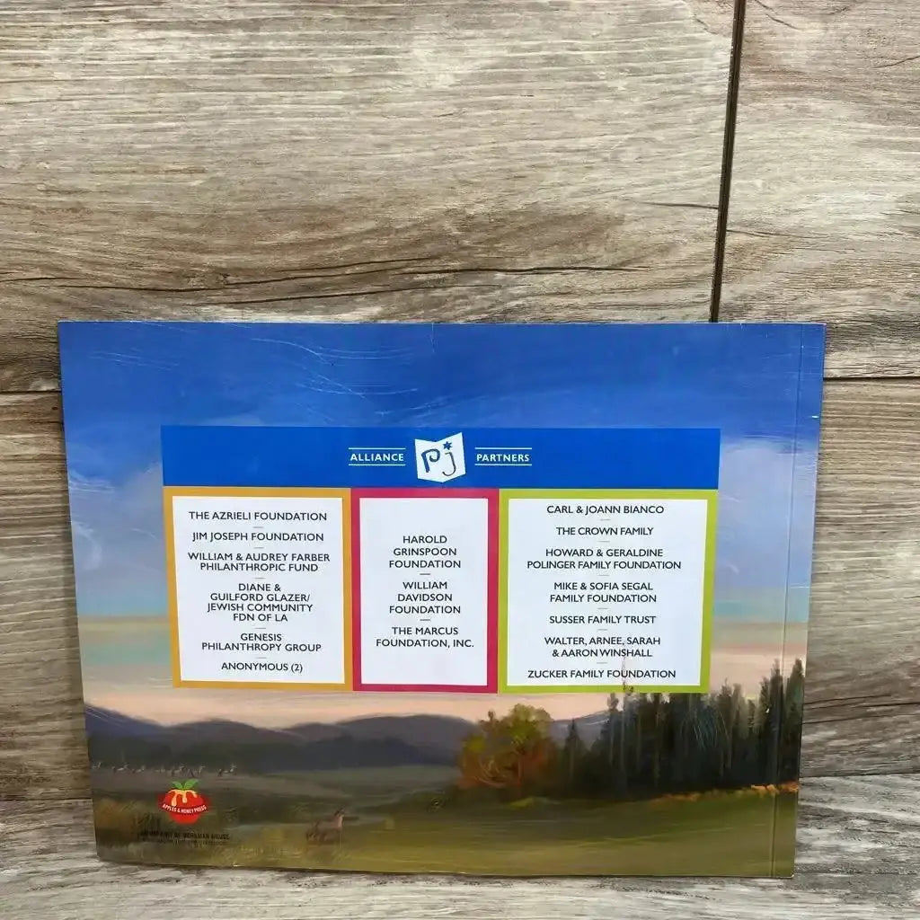 Back cover of Big Sam A Rosh Hashanah Tall Tale paperback book showcasing PJ Library Alliance Partners panel over meadow landscape on wood plank background