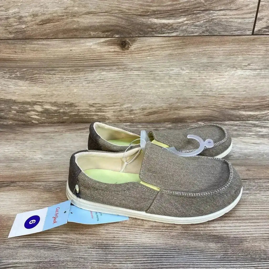 Side view of Cat and Jack Bergen beige slip-on sneakers size 6Y showing moccasin-style stitching and white rubber sole on wood background