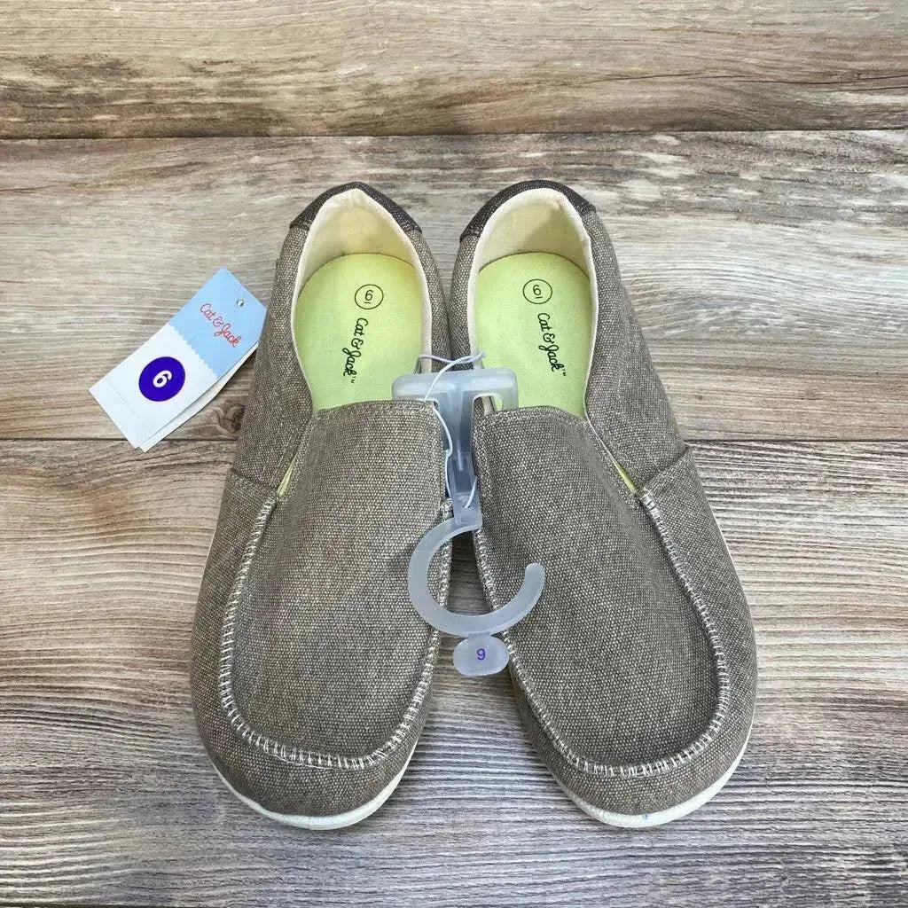 Top view of beige Cat and Jack Bergen slip-on kids sneakers showing elastic gore, lime-green insoles on wood background