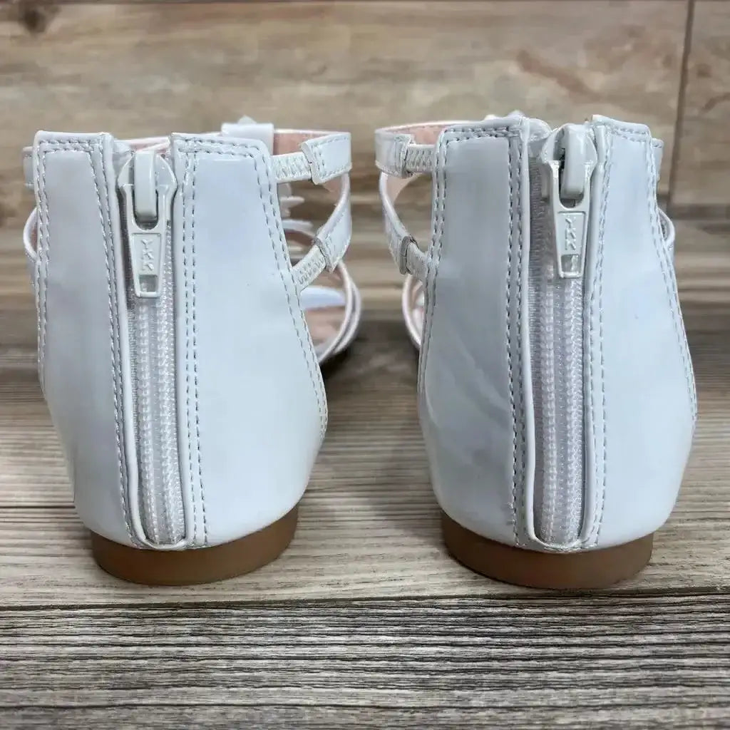 Back view of NWT SO Loganberry gladiator sandals in white with back zip closure and tan sole on wood plank floor