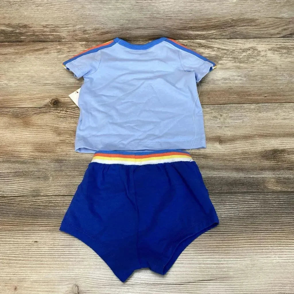 Flat lay of Cat & Jack baby shirt and shorts, light blue top and blue shorts with rainbow-striped elastic waistband on wood background