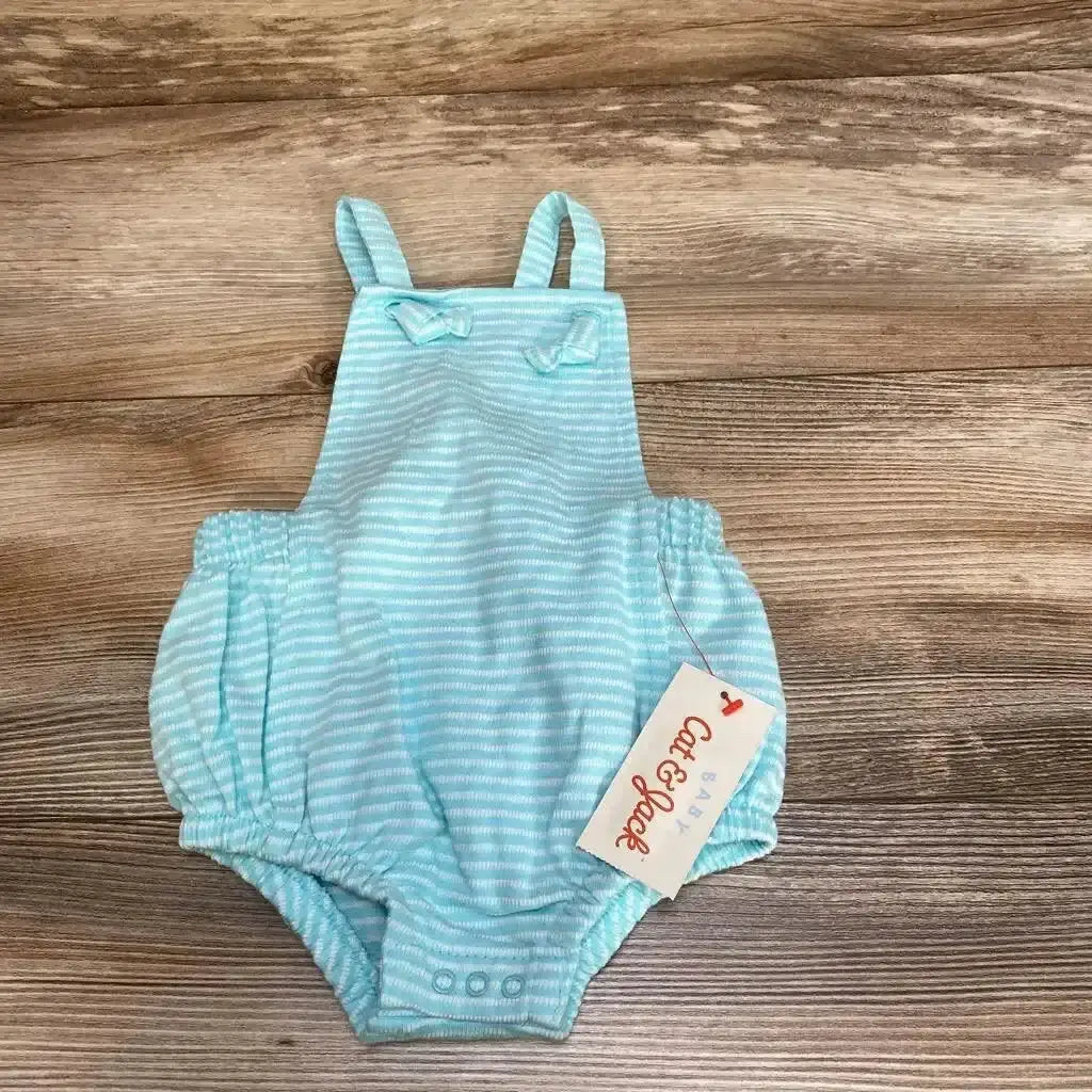 Front view of NEW Cat & Jack striped romper sz 3-6M showcasing aqua and white stripes, shoulder straps, and snap closures on a wood background