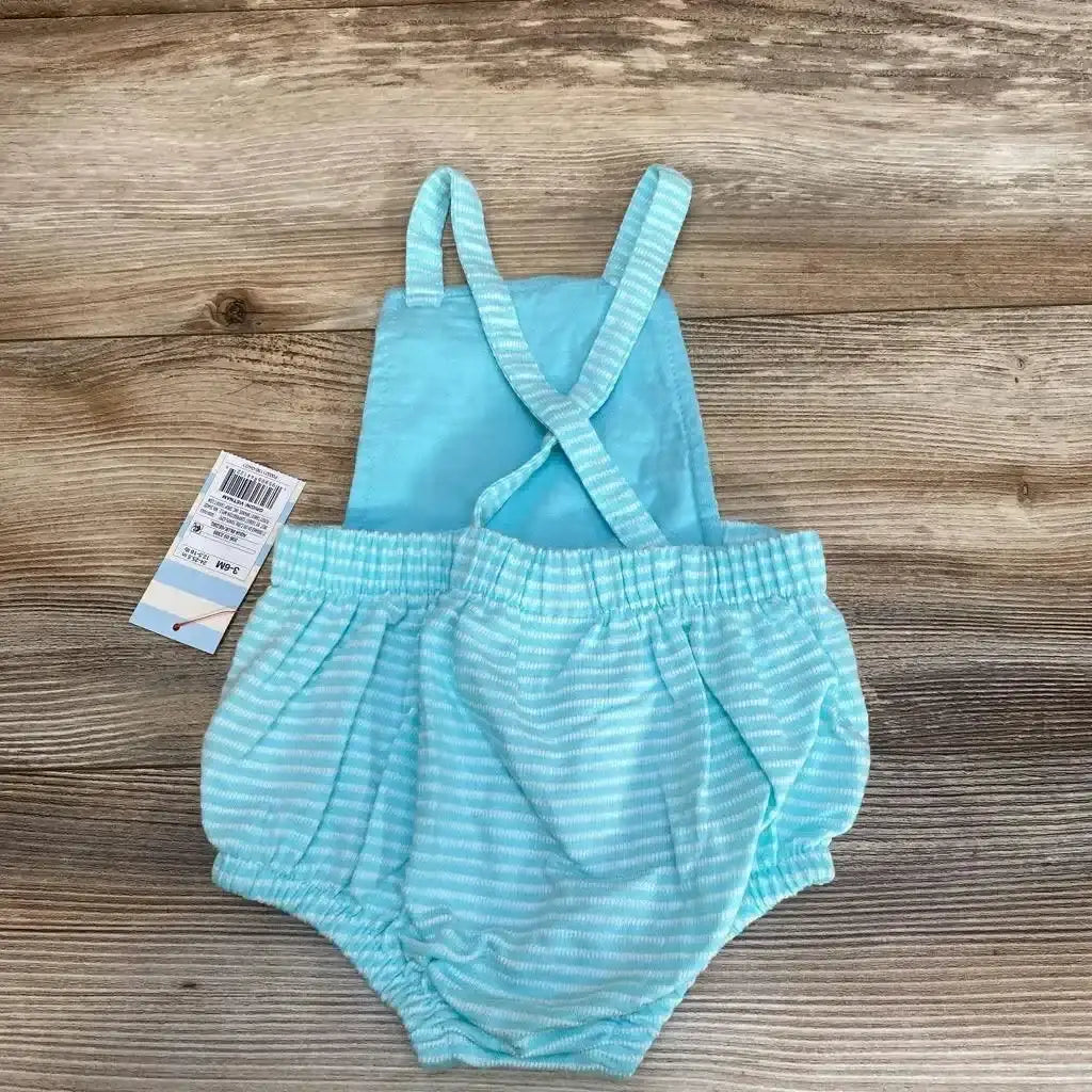 Front view of Cat and Jack striped romper, size 3 to 6 months, with crossed straps and elastic waist on wood background