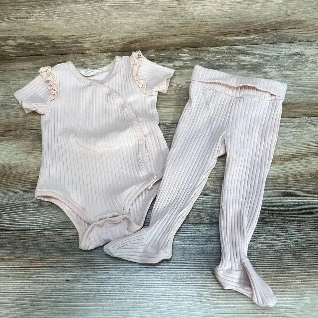 Flat lay of pale pink ribbed Jessica Simpson bodysuit and footed pants, 6-9m, ruffle lace sleeves and footed legs on wood