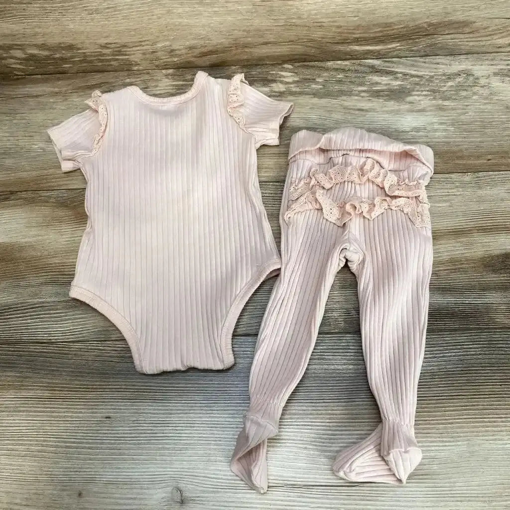 Flat lay of Jessica Simpson pink ribbed bodysuit and footed pants set (6-9M) with lace ruffles on wood