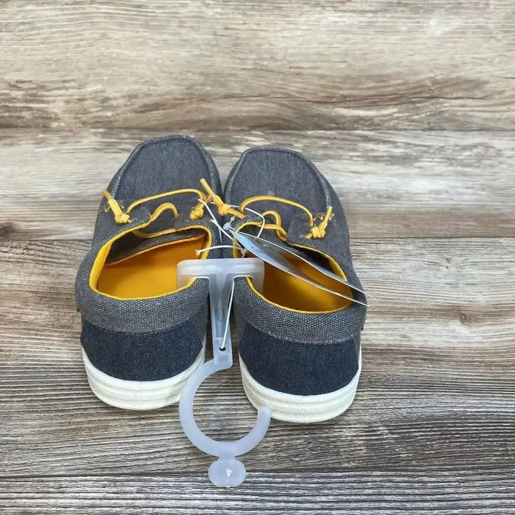 Rear view of Cat and Jack Briar slip-on sneakers, size 4Y, grey canvas with yellow lining and elastic laces on wood background
