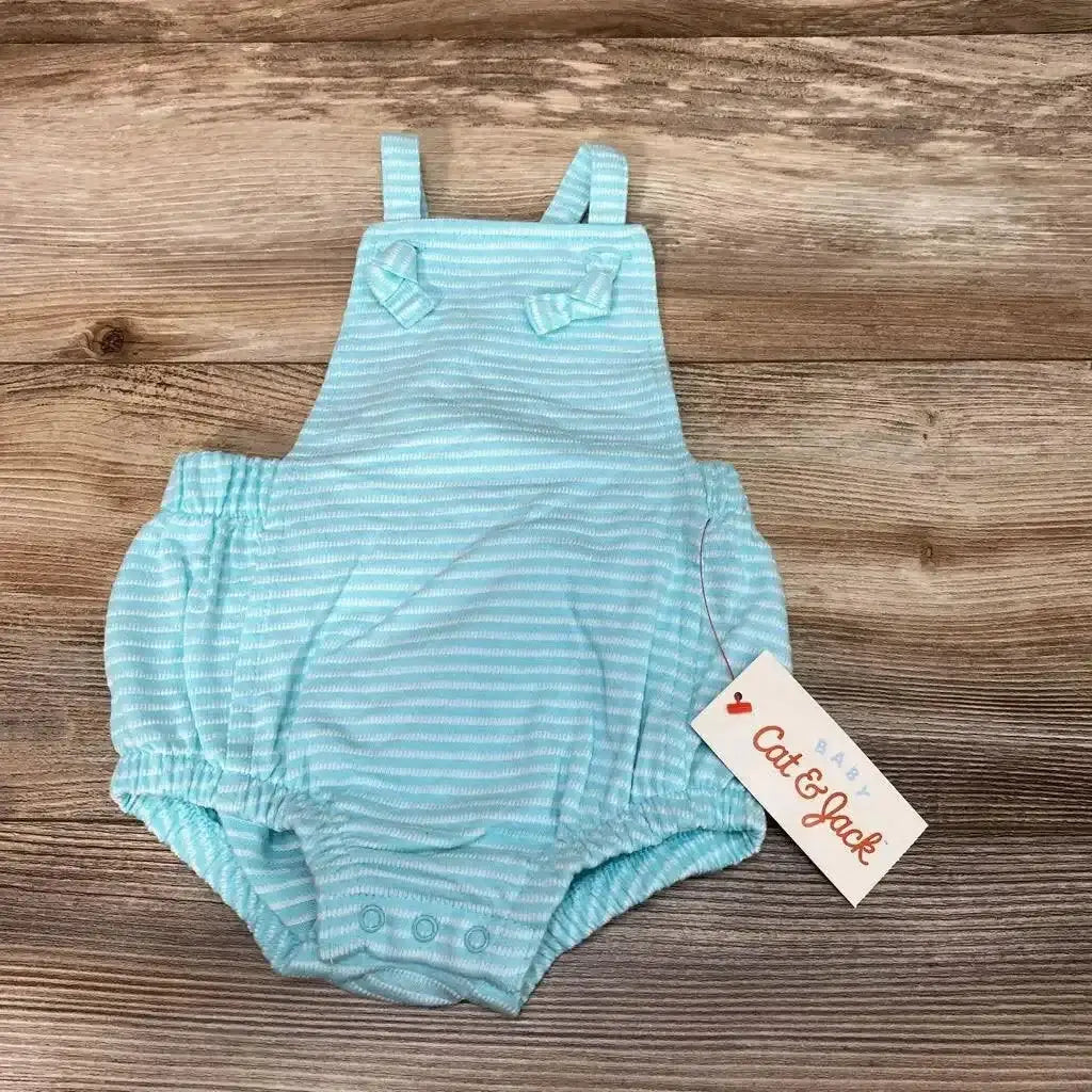 Flat lay of Cat and Jack light blue striped romper size 3-6M showing bib straps and crotch snaps on wood background