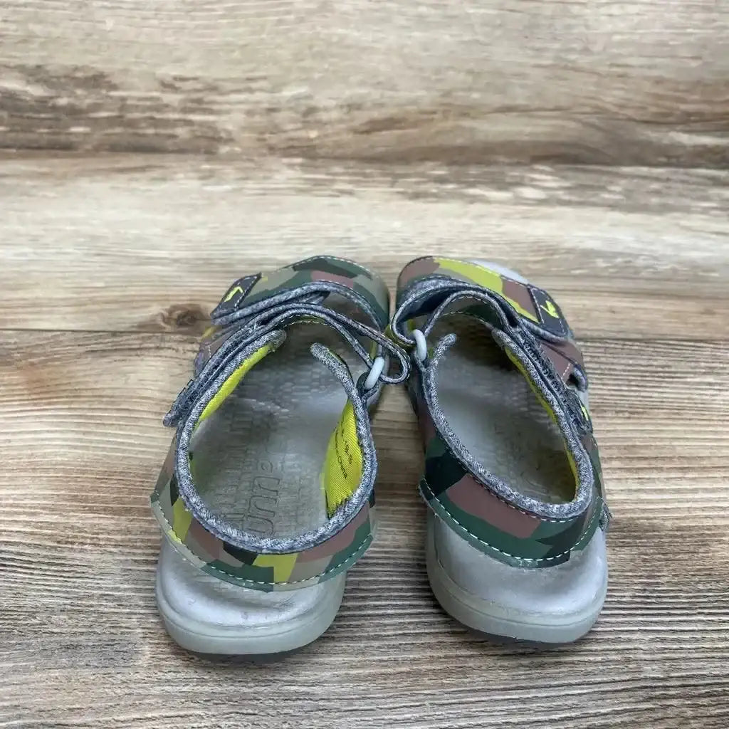 Rear-top view of See Kai Run Billie Flexirun toddler sandals size 12C showcasing camouflage print and adjustable Velcro straps on wood floor background