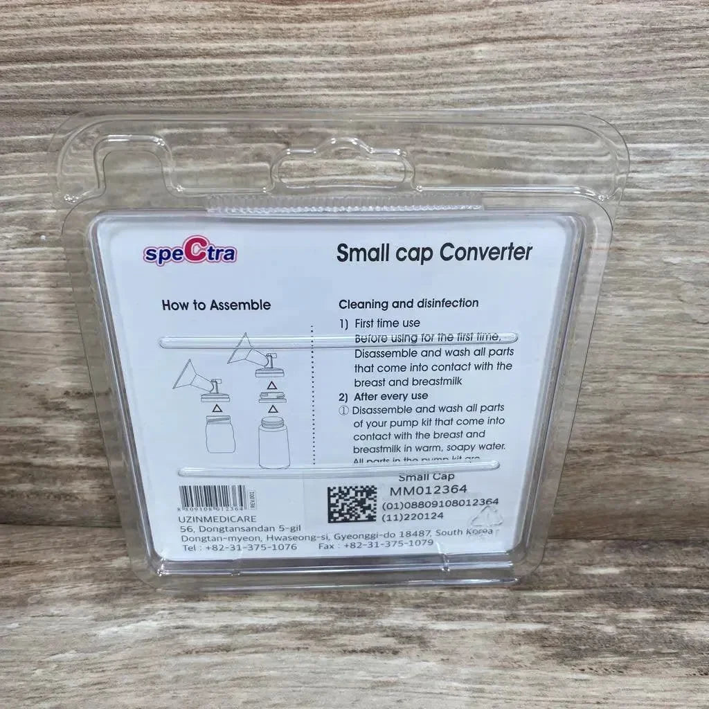 Front of Spectra Small Cap Converter in clear plastic packaging showing assembly diagram and instructions on wood surface