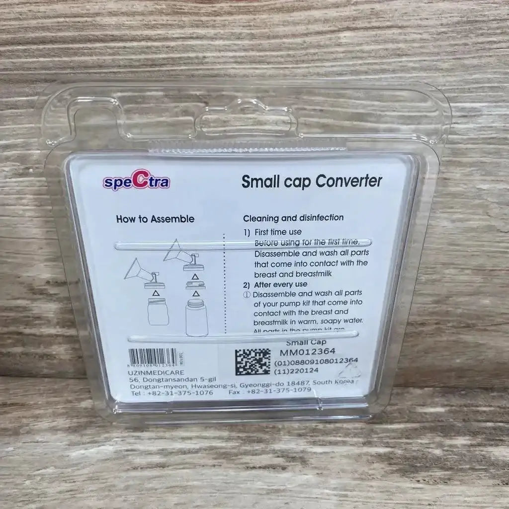 Front of Spectra Small Cap Converter in clear plastic packaging showing assembly diagram and instructions on wood surface