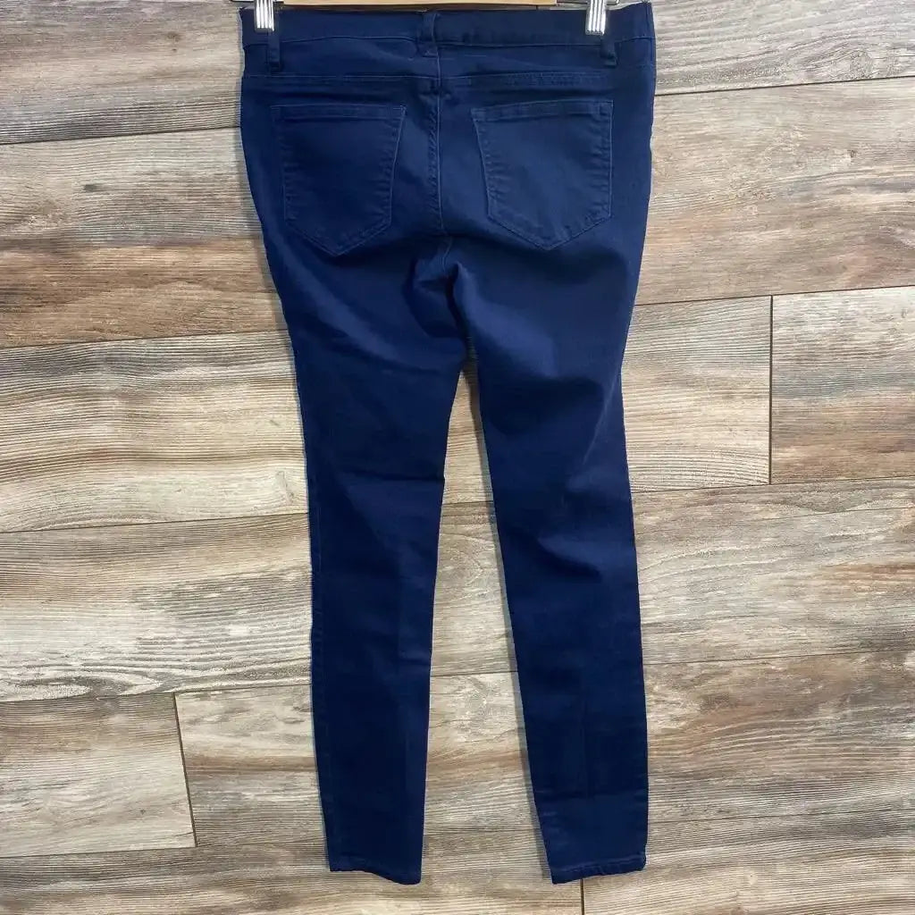 Back view of navy side-panel maternity pants, size XS, showing elastic side panels and back pockets on wood floor
