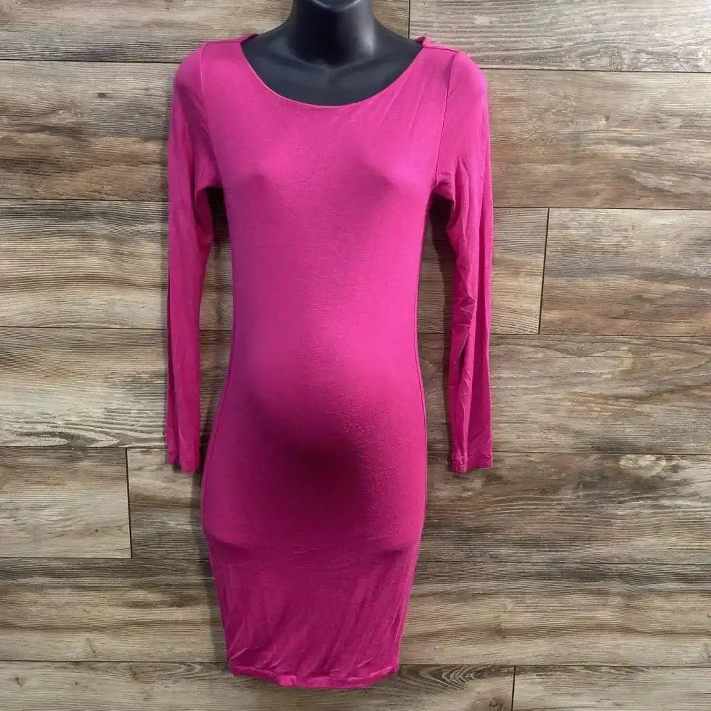 Front view of pink long-sleeve maternity bodycon dress with fitted shape and visible bump on black mannequin wood background