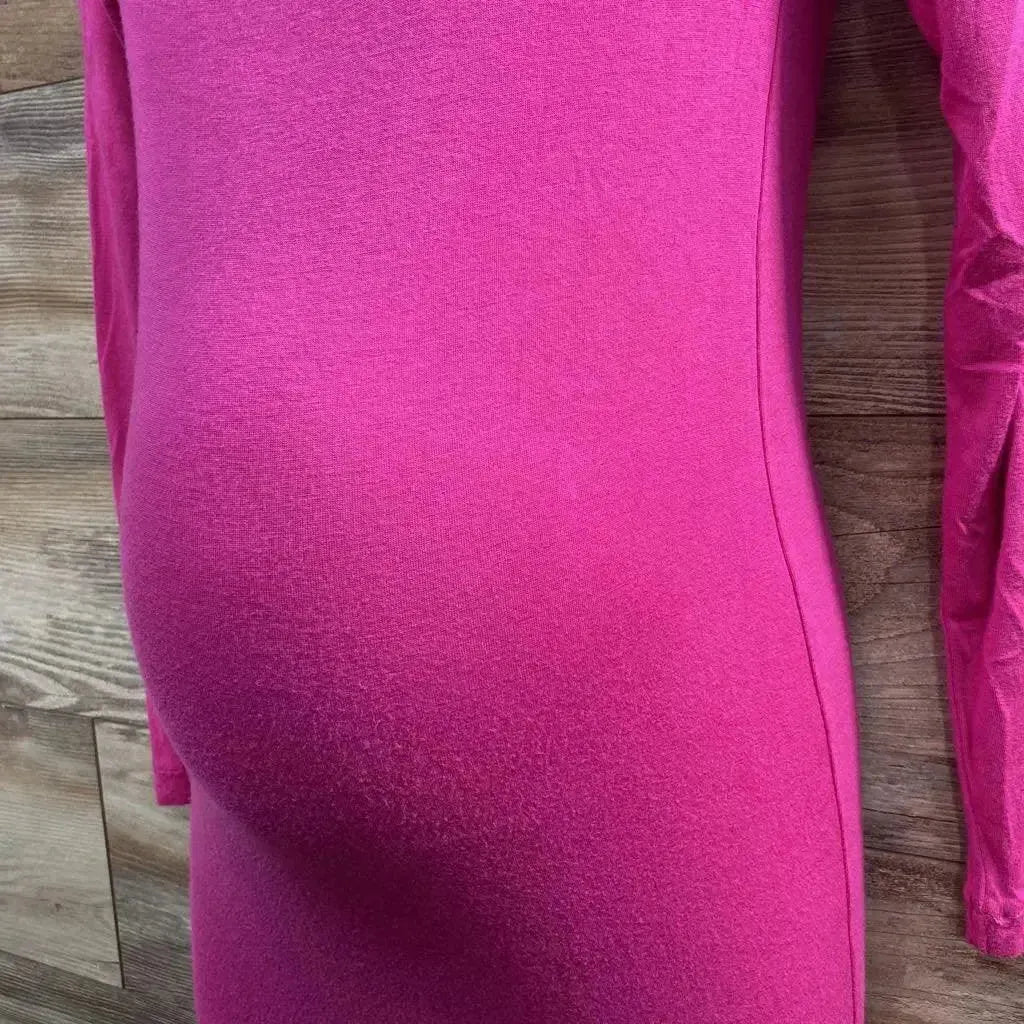 Close-up side view of pink maternity dress (XS) showing fitted stretch fabric over baby bump with wood plank background
