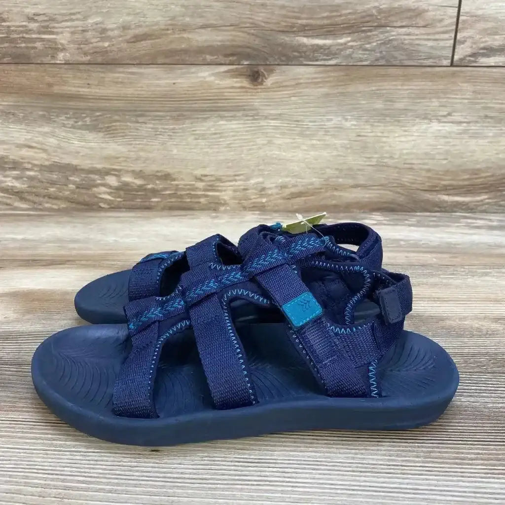 Side view of navy All in Motion Lumi kids sandals showing adjustable ankle and toe straps and textured footbed on wood background
