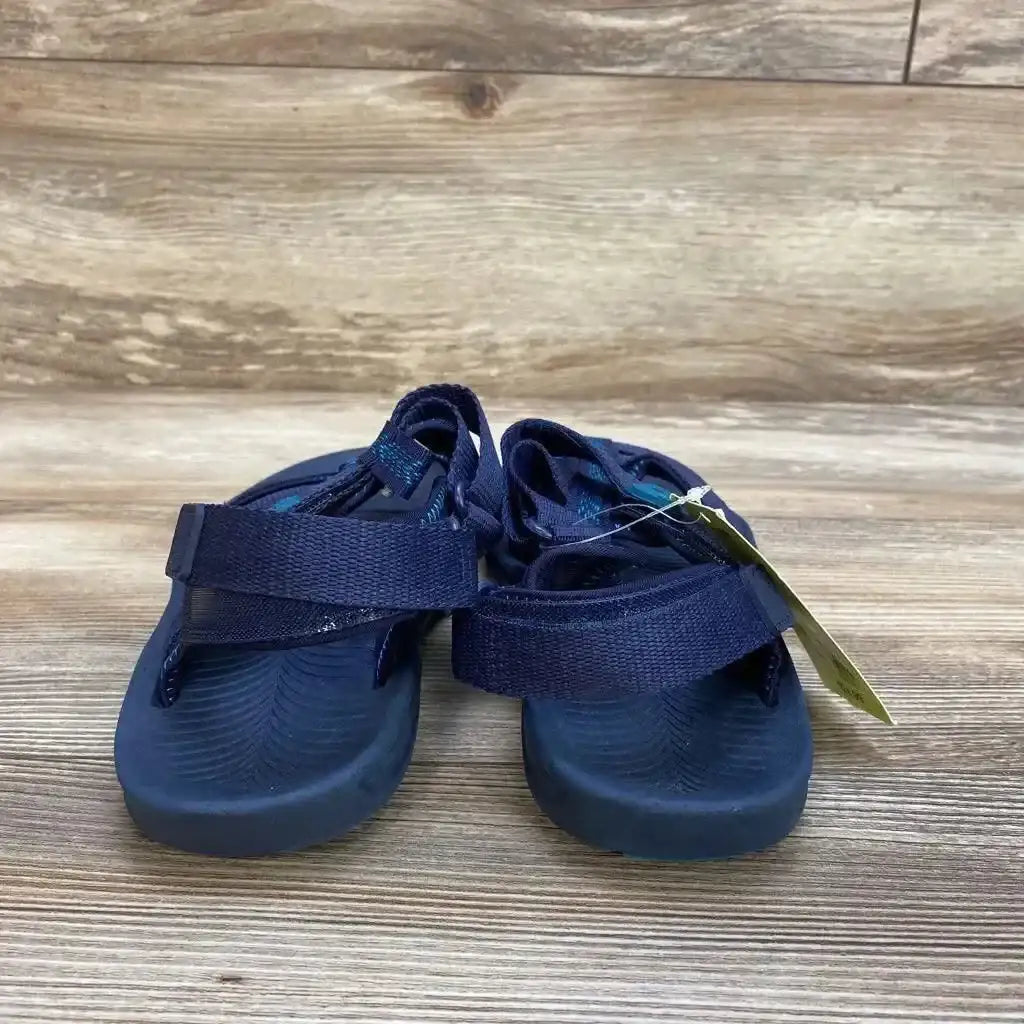 Three-quarter view of NEW All in Motion Lumi Ankle Strap Sandals sz 6Y showcasing navy webbed strap sport sandals with hangtag on wood plank floor