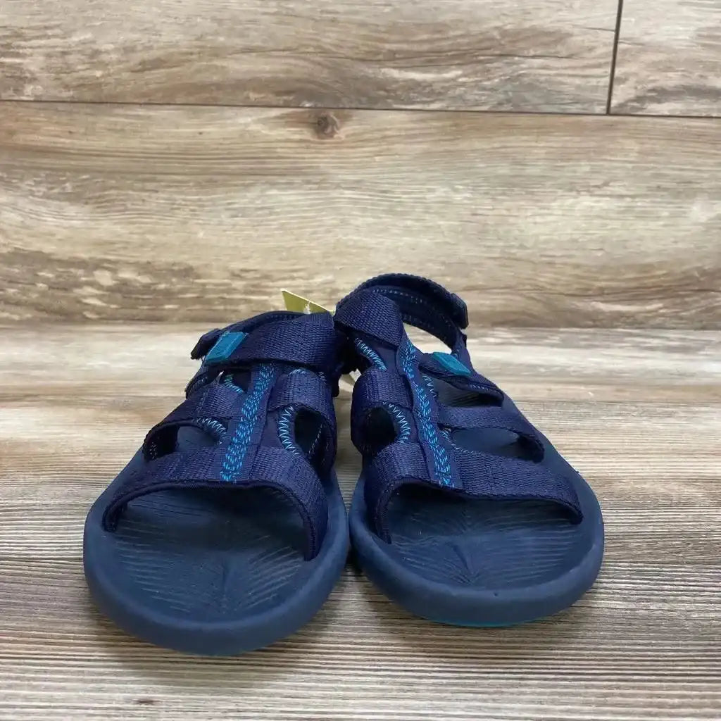 Front view of navy All in Motion Lumi ankle-strap sandals with Velcro straps and textured footbed on wood background