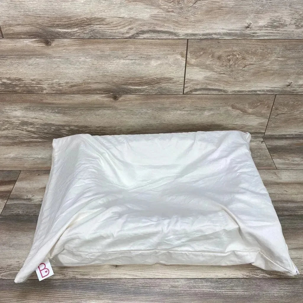 Top view of Ivory Belly Baby pregnancy pillow showing center contour and removable cover on wood-plank background