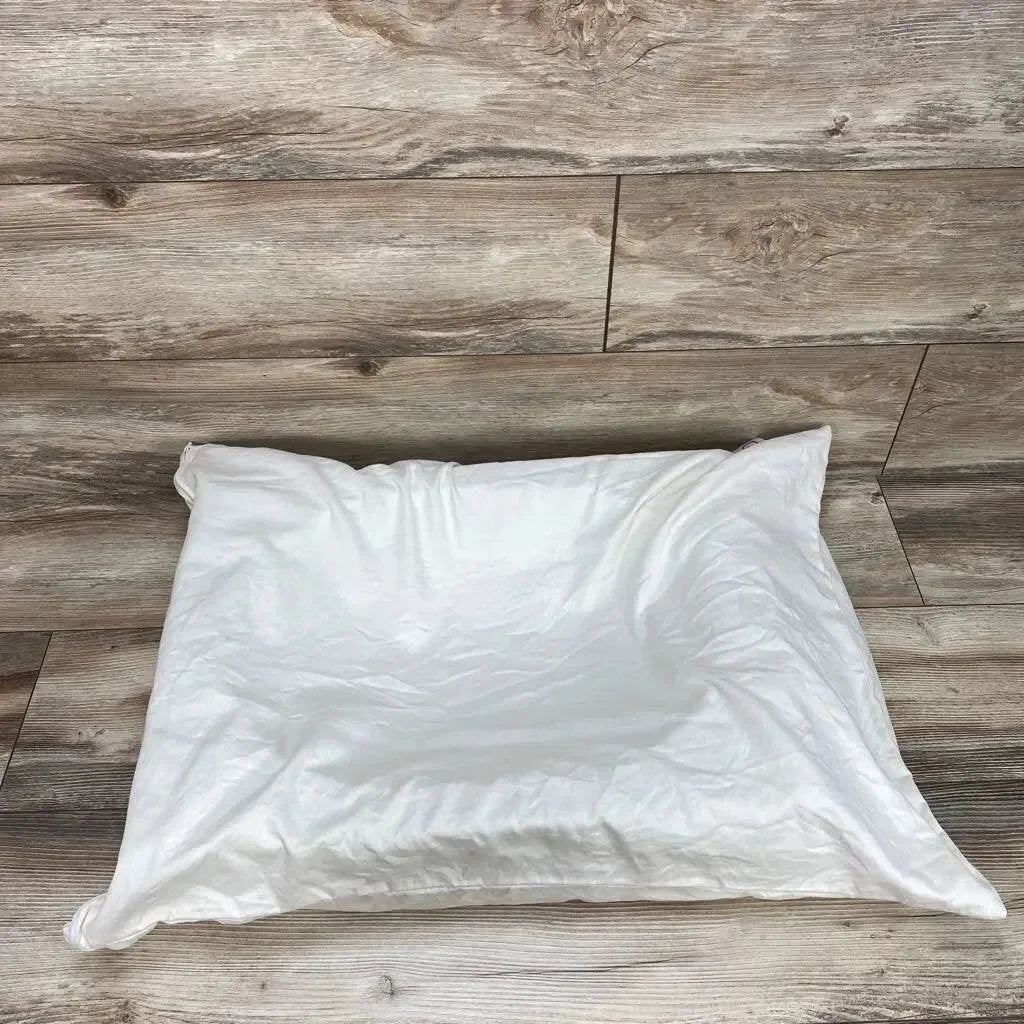 Top down view of ivory Belly Baby breast pregnancy pillow showcasing central contoured support and white cover on wood plank background