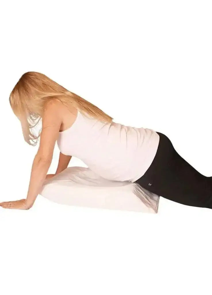 Side view of Ivory Belly Baby Breast pregnancy pillow supporting pregnant woman leaning on forearms, white background