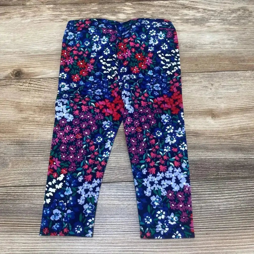 Front view of Janie & Jack floral ponte pants in size 6-12m showcasing elasticized waist on a wood-grain background