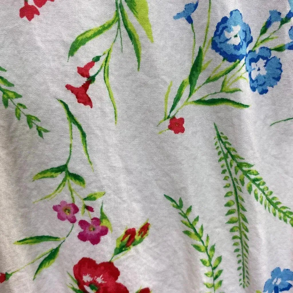 Close-up of Janie and Jack white 3T dress showing watercolor-style blue, red, and pink floral print on white fabric
