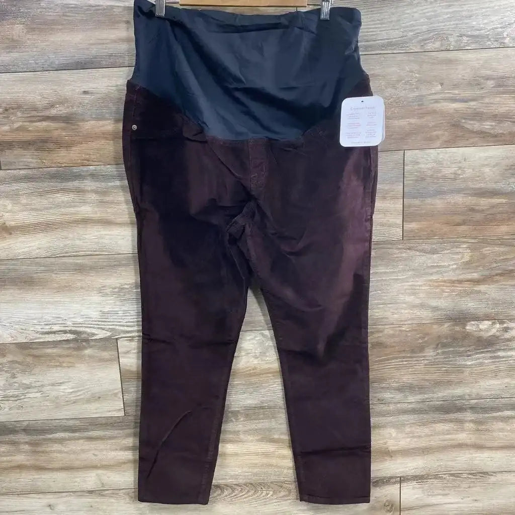 Flat lay of Isabel maternity crossover-panel skinny jeans with black crossover tummy panel on wood floor