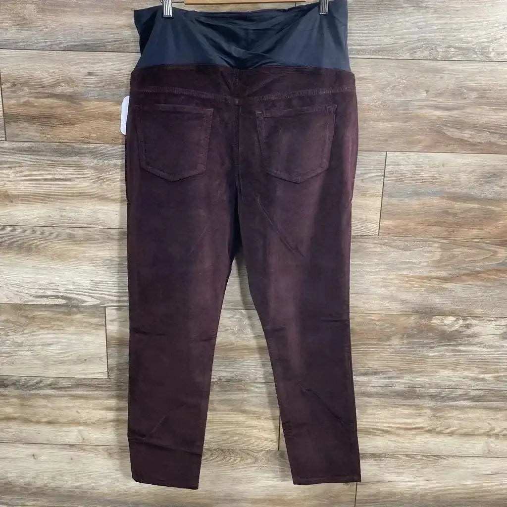 Back view of Isabel Maternity Crossover Panel Skinny Jeans in burgundy with black stretch panel and back pockets on wood plank floor