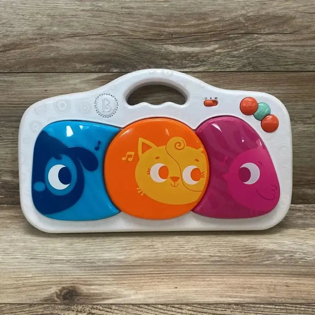 Front view of B. Toys Musical Party Dance Pad with three colorful light-up animal pads and handle on wood background