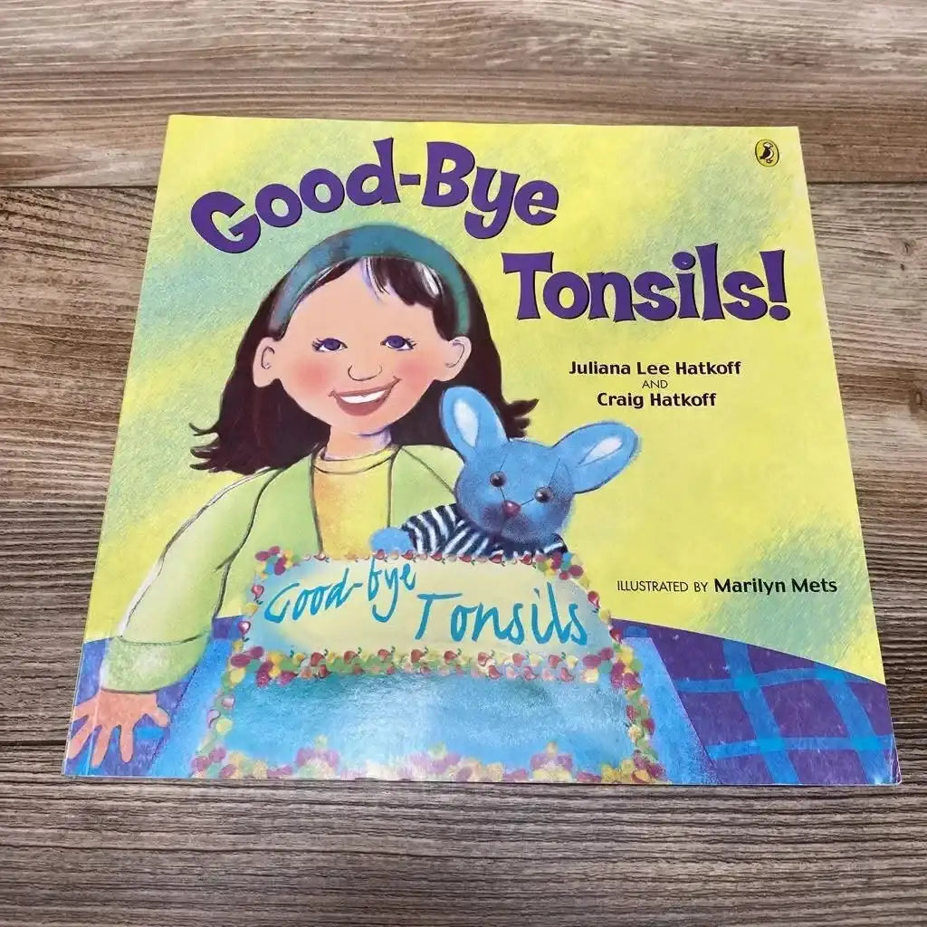 Front cover of Good-bye Tonsils! paperback book showing a girl, blue rabbit, and cake on a wooden surface