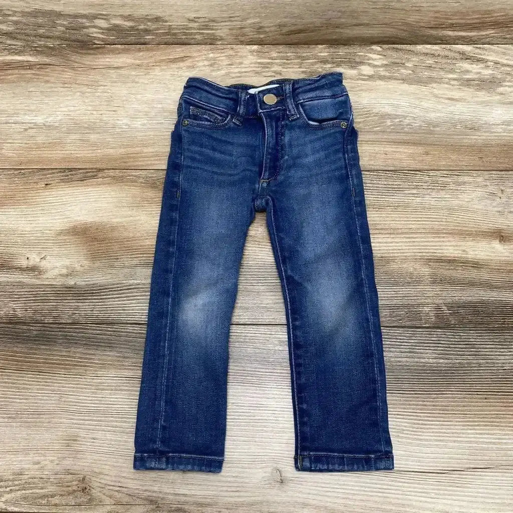Flat lay of DL 1961 Chloe Skinny Jeans sz 2T showcasing medium dark wash denim with whiskering and five-pocket styling on wood plank background