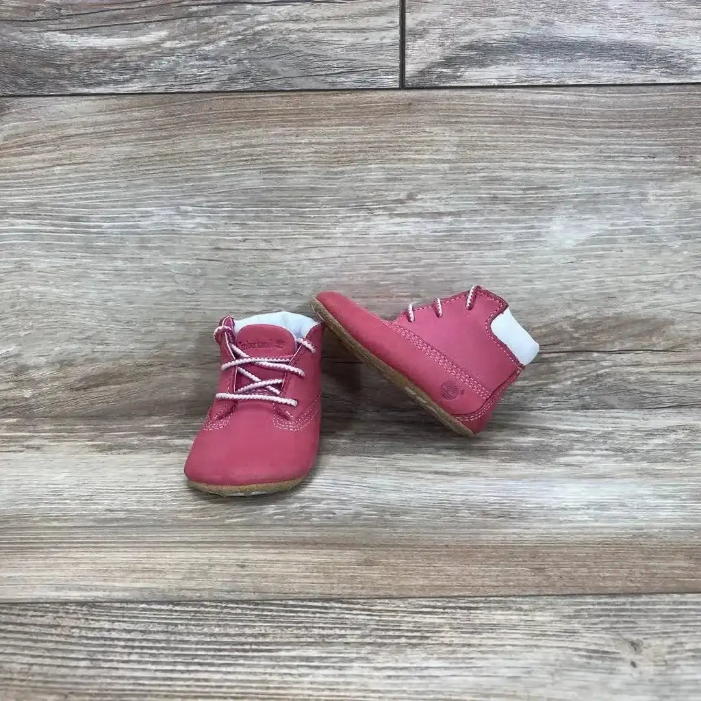 Front view of pink Timberland infant crib booties size 1C showing soft sole and ankle cuff on white background