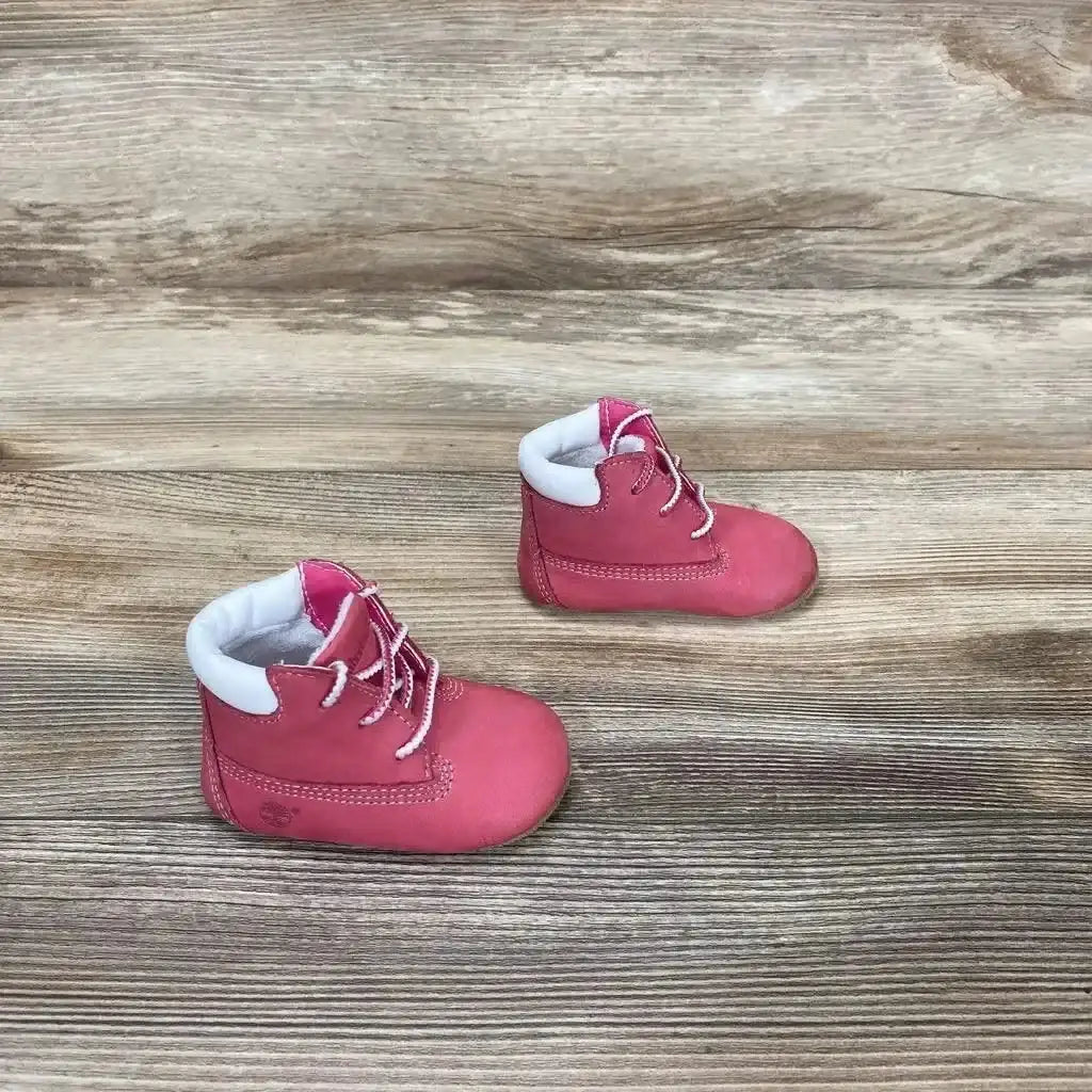 Front view of pink Timberland infant crib booties size 1C showing soft sole and ankle cuff on white background