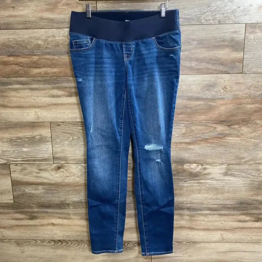 Flat lay of Old Navy maternity low-panel skinny jeans, size small, showing low belly panel and distressed knees on wood floor