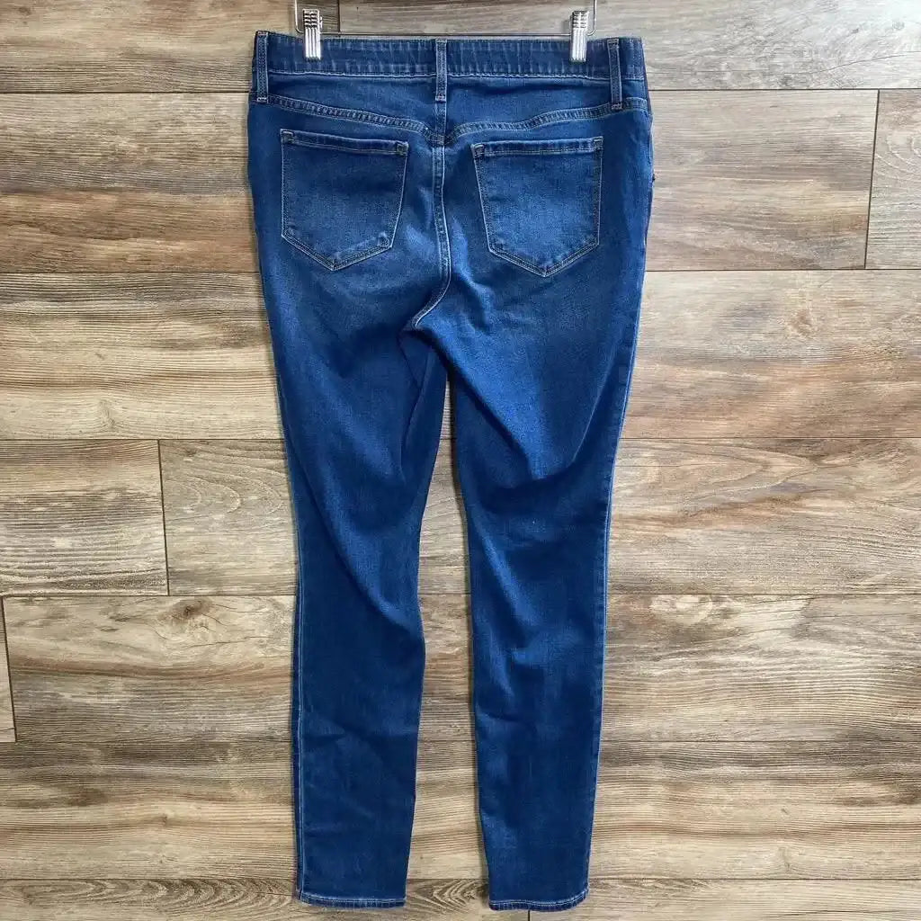 Back view of Old Navy maternity low-panel skinny jeans, blue, size small, showing back pockets and skinny legs on wood floor