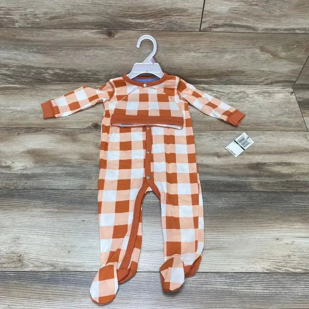 Front view of orange and white check footed sleeper with snaps and matching hat on hanger over wood floor, new with tag