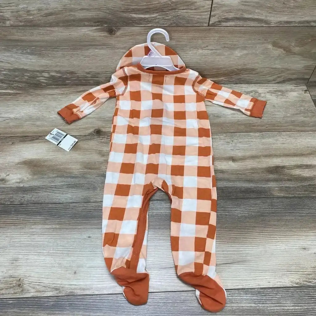 Flat-lay front of orange and white buffalo-check footed sleeper with matching hat, size 6–9 months on wood floor