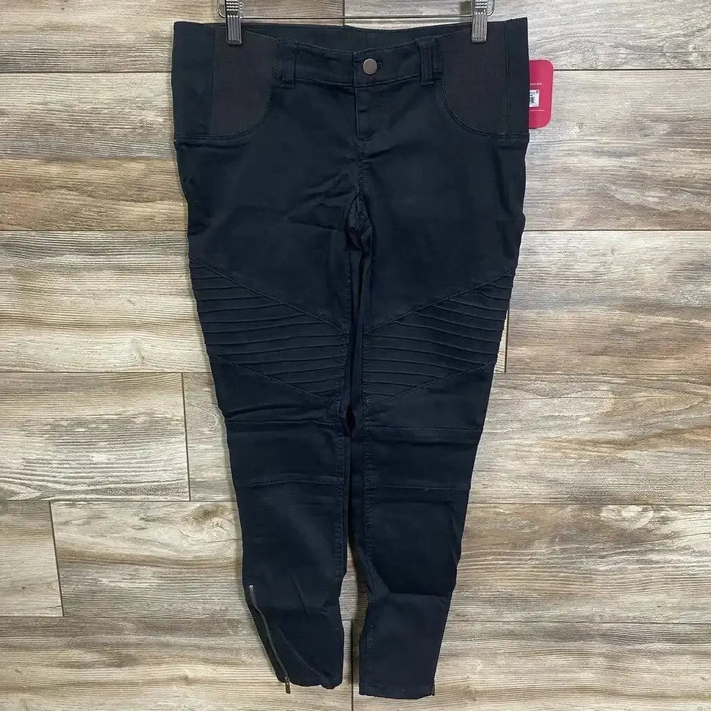 Front flat lay of black Isabel maternity jeggings with elastic belly panel, moto knee ribbing and ankle zippers on wood floor