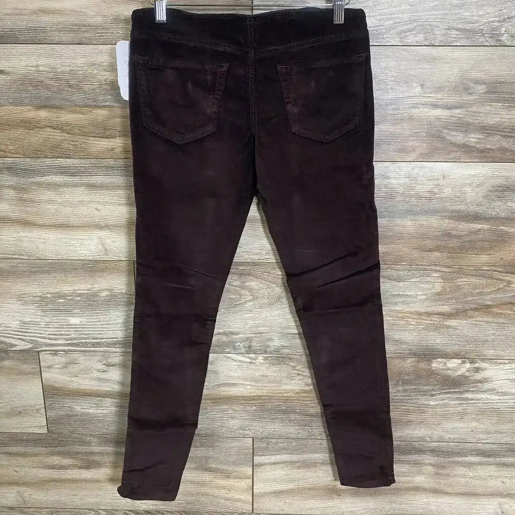 Back view of burgundy Isabel maternity crossover-panel skinny jeans with back pockets and corduroy texture on wood floor