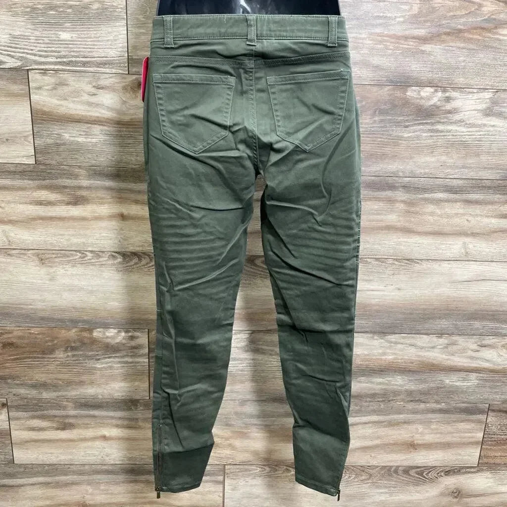 Back view of olive Isabel maternity utility jeggings showing back pockets, ankle zips and tapered legs on wood floor