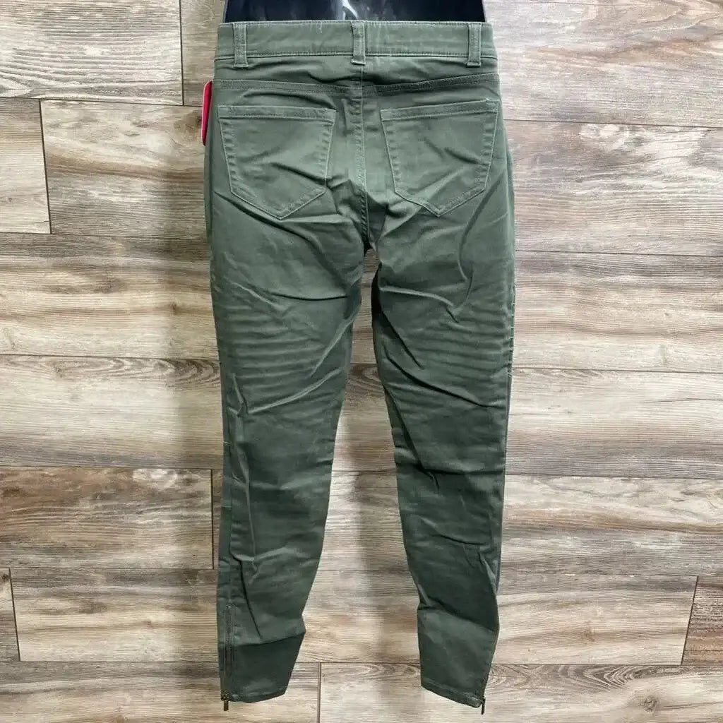 Back view of olive Isabel maternity utility jeggings showing back pockets, ankle zips and tapered legs on wood floor