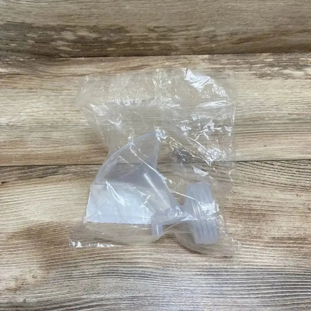 Top view of new Spectra clear silicone breast pump flange 28mm in sealed plastic bag on wood plank floor
