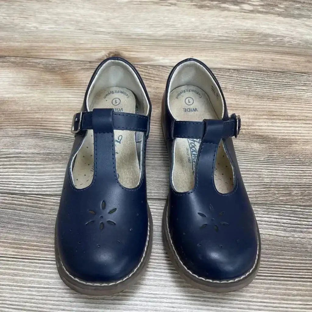 Top view of Footmates Sherry Mary Jane shoes in navy leather with T-strap buckle and floral cutout detail on wood plank floor