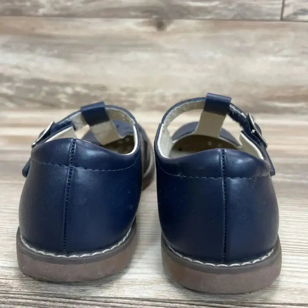 Rear view of navy Footmates Mary Jane toddler shoes size 1Y showing buckle strap and worn soles on wooden floor