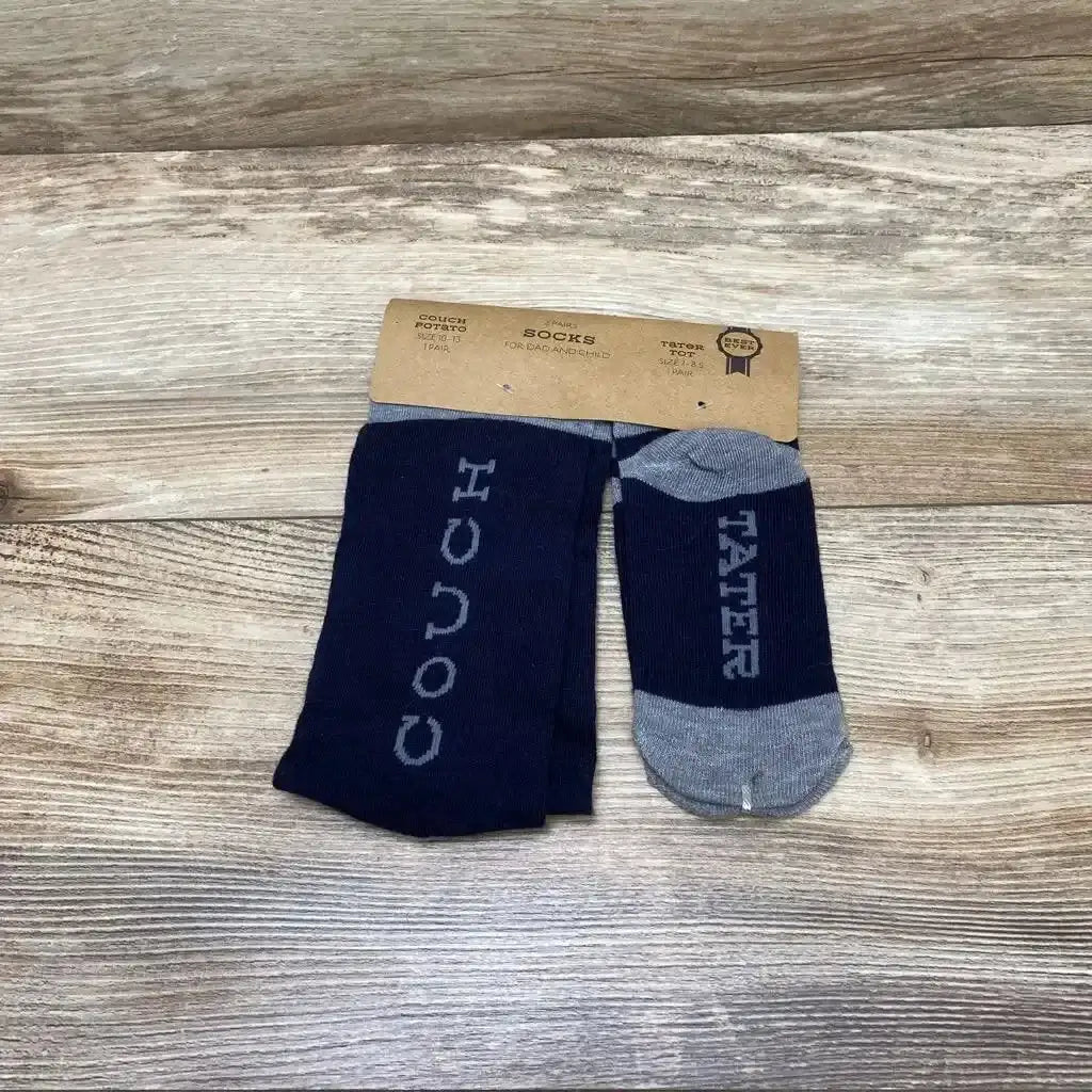 Top down view of navy dad and child socks showing COUCH on adult sock and TATER on child sock on wood background