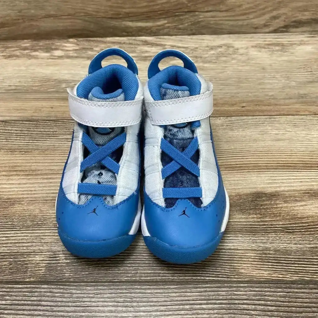 Front view of Jordan 6 Rings TD White Dutch Blue toddler sneakers showcasing hook and loop strap and Jumpman logo on wood plank floor