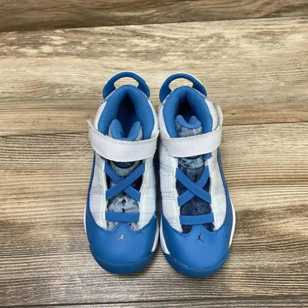 Top view of Jordan 6 Rings TD White Dutch Blue Sneakers showcasing blue and white upper hook-loop strap with Jumpman logo on wood plank floor