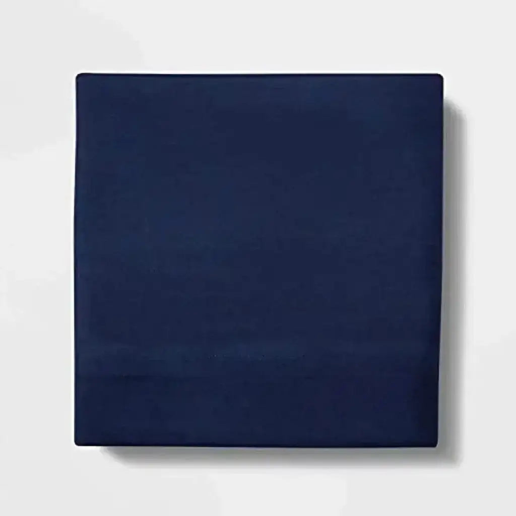 Folded navy Pillowfort microfiber flat sheet showing smooth fabric and stitched hem on white background